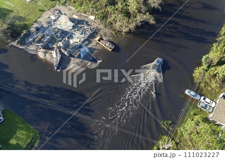 Aerial view of flooded street after hurricane rainfall with driving cars in Florida residential area. Consequences of natural disaster Aerial view of flooded street after hurricane rainfall with driving cars in Florida residential area. Consequences of natural disaster 111023227