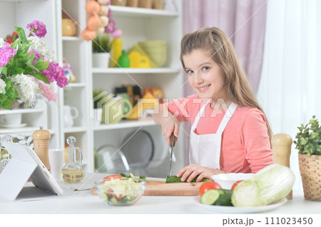 Portrait of young girl cooking in kitchen Portrait of young girl cooking in kitchen 111023450