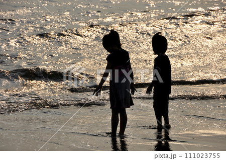 波打ち際の兄弟　シルエット　海辺の輝き 111023755