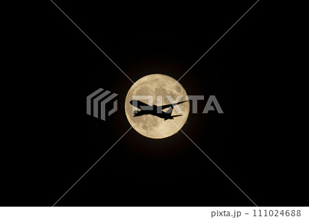 夜空に浮かぶ満月と飛行機のシルエット 111024688