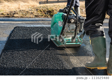 道路工事　アスファルトの舗装復旧工事　転圧作業 111025480