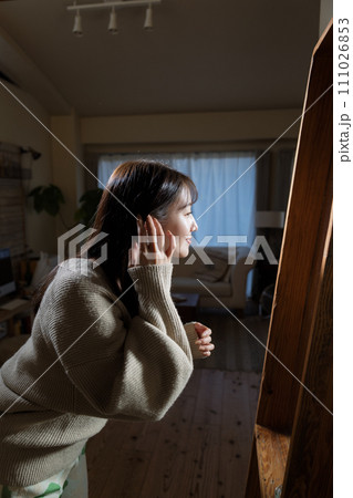 鏡を見ながら髪の毛を整える女性 111026853