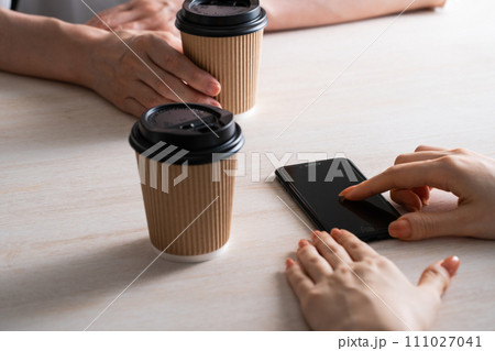 ドリンクを飲みながらスマホを触る手元 ドリンクを飲みながらスマホを触る手元 111027041