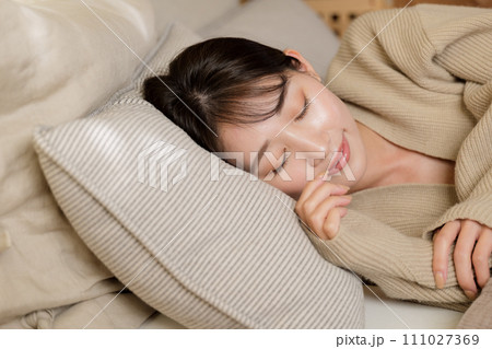 寝室のベッドで眠る女性 111027369