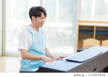 ピアノを弾く男性保育士 111027636