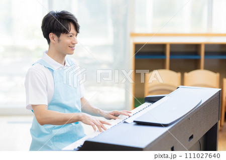 ピアノを弾く男性保育士 111027640