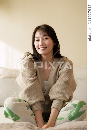 ベッドの上でリラックスして過ごす女性 ベッドの上でリラックスして過ごす女性 111027917