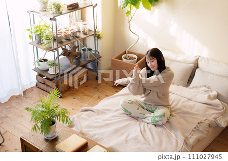 ベッドの上でリラックスして過ごす女性 111027945