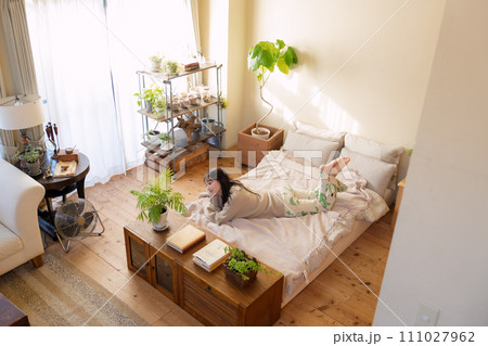 ベッドの上でリラックスして過ごす女性 ベッドの上でリラックスして過ごす女性 111027962