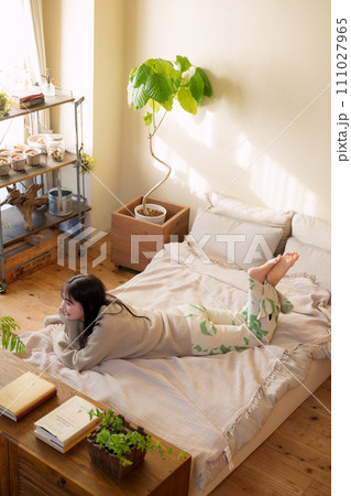 ベッドの上でリラックスして過ごす女性 ベッドの上でリラックスして過ごす女性 111027965