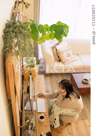 部屋でパソコンを触る女性 111028657