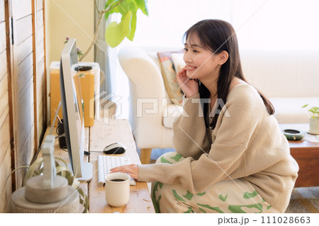部屋でパソコンを触る女性 部屋でパソコンを触る女性 111028663
