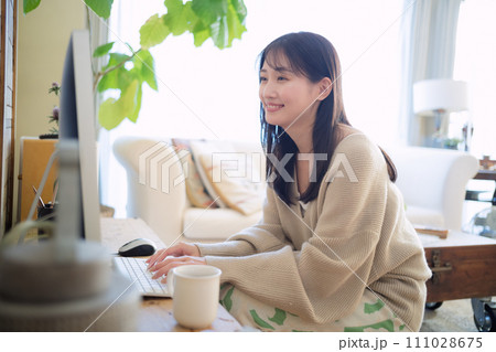 部屋でパソコンを触る女性 111028675