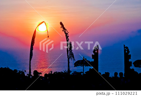 views of Penjor, Janur and Balinese temples with the sunset of Uluwatu, Bali 111029221