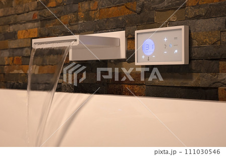 Modern digital watertap, filling the white bath Modern digital watertap, filling the white bath 111030546