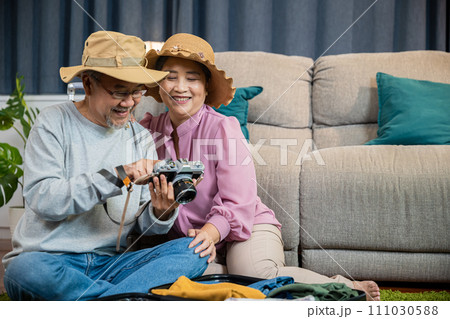 Travel and tourism. Happy mature retired couple photography weekend holiday, Asian couple old senior marry retired couple smiling taking photo by camera during luggage suitcase arranging for travel Travel and tourism. Happy mature retired couple photography weekend holiday, Asian couple old senior marry retired couple smiling taking photo by camera during luggage suitcase arranging for travel 111030588