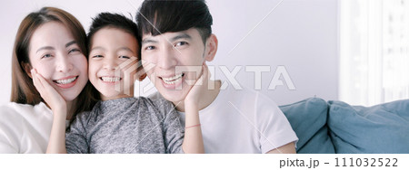 Happy family and child hugging and looking at camera 111032522