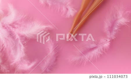 Doll's feet in plastic shoes lying on white feathers on pink background 111034073