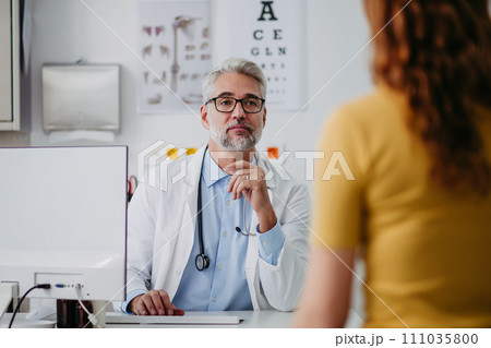 Portrait of doctor talking with tennage girl patient, during visit. Concept of preventive health care for adolescents. Portrait of doctor talking with tennage girl patient, during visit. Concept of preventive health care for adolescents. 111035800