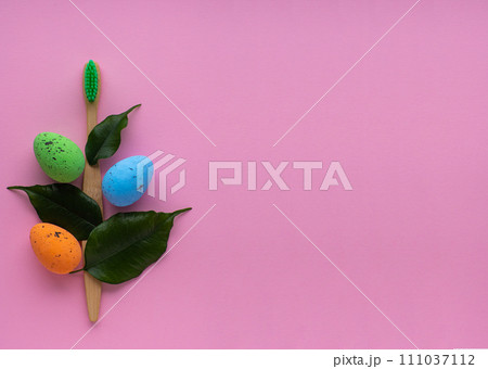 Wooden toothbrush with Easter decorations on pink background Wooden toothbrush with Easter decorations on pink background 111037112