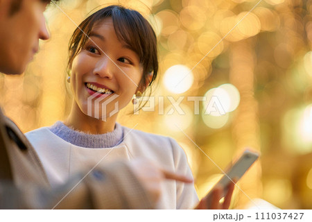 楽しげにスマートフォンを操作する女性と男性 111037427