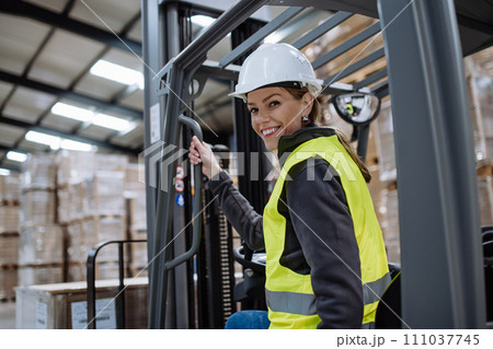 Female warehouse worker driving forklift. Warehouse worker preparing products for shipmennt, delivery, checking stock in warehouse. Banner with copy space. 111037745
