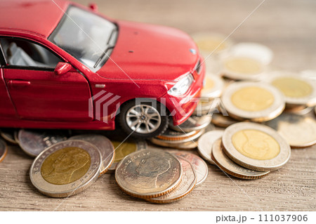 BANGKOK, THAILAND - FEBRUARY 12, 2023, Car on coins background; Car loan, Finance, saving money, insurance and leasing time concepts. 111037906