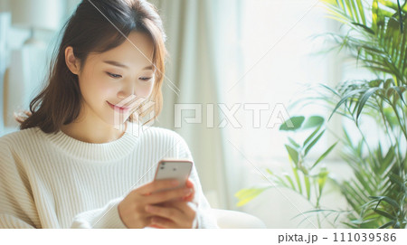 笑顔でスマホを操作する女性 111039586