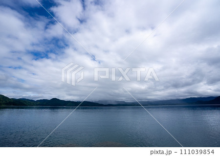 低い雲の間に広がる青空と秋の田沢湖 低い雲の間に広がる青空と秋の田沢湖 111039854