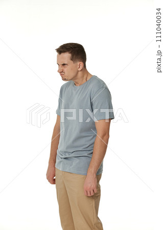 annoyed angry man standing on white studio background annoyed angry man standing on white studio background 111040034