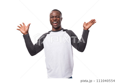 young handsome american man dressed in a long-sleeved sweater announces the news using gestures 111040554