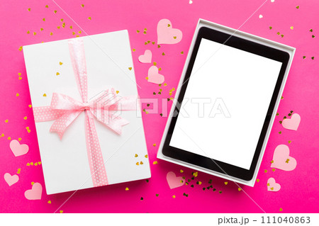 Gift box of open tablet for the holidays with a bow top view Gift box of open tablet for the holidays with a bow top view 111040863