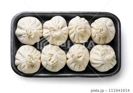 Raw khinkali in a plastic tray on a white background. Top view 111041014