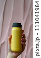 a hand holding a matte yellow water bottle  Genearative AI  111041984