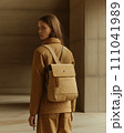 a beige, single-strap backpack or sling bag displayed against a neutral background.  Genearative AI 111041989