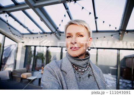 Close-up selfie of fashionable mature woman with chic short blonde hair, captivating in sleek grey turtleneck and jacket, perfect combination of elegance and confidence Close-up selfie of fashionable mature woman with chic short blonde hair, captivating in sleek grey turtleneck and jacket, perfect combination of elegance and confidence 111043091