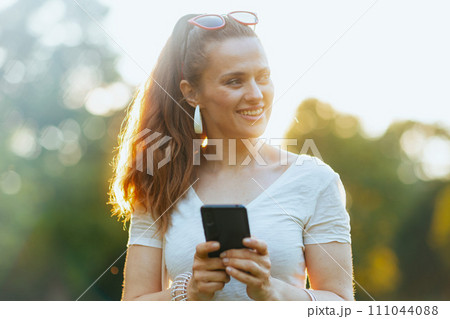 happy woman in shirt using smartphone applications 111044088