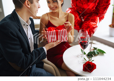 Exchange of gifts. Young couple celebrating Valentine's Day. Romantic evening in a restaurant. Exchange of gifts. Young couple celebrating Valentine's Day. Romantic evening in a restaurant. 111044234