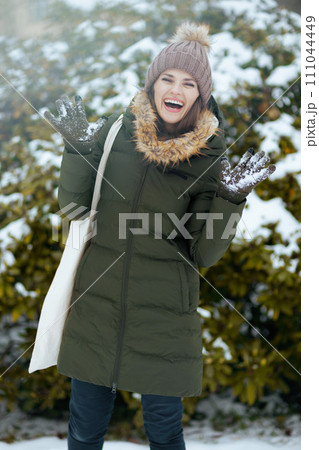 happy modern woman outdoors in city park in winter 111044449