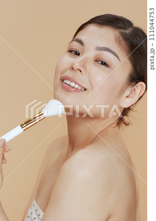 modern asian female with makeup brush 111044753