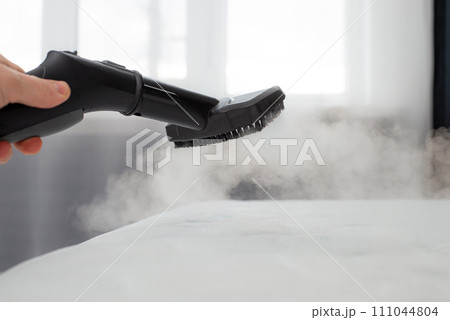 Cleaning and disinfection of the mattress in the bedroom with hot steam. Professional cleaning process Cleaning and disinfection of the mattress in the bedroom with hot steam. Professional cleaning process 111044804