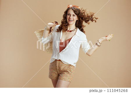 happy trendy woman in blouse and shorts on beige happy trendy woman in blouse and shorts on beige 111045268