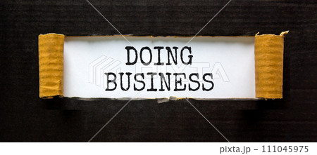 Doing business symbol. Concept words Doing business on beautiful white paper. Beautiful black table black background. Business, motivational Doing business concept. Copy space. Doing business symbol. Concept words Doing business on beautiful white paper. Beautiful black table black background. Business, motivational Doing business concept. Copy space. 111045975