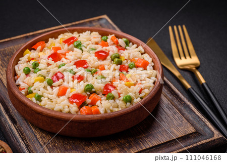 Delicious white boiled rice with vegetables, sweet peppers, carrots, peas, salt and spices 111046168