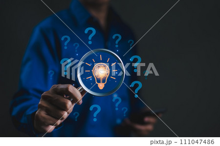 The concept of using creative thinking to help solve problem. Innovation patent, Find solution, think idea, Businessman holding magnifying glass icon with many idea light bulb and question marks. 111047486