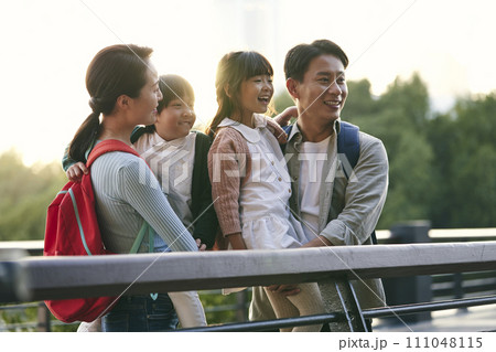 asian family with two children looking at view in city park 111048115