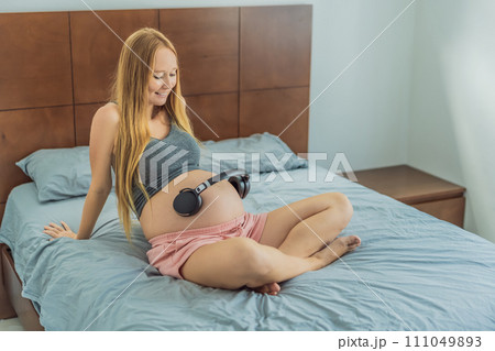 Expectant mom finds joy in her pregnancy, listening to soothing music for a serene and harmonious connection with her unborn baby Expectant mom finds joy in her pregnancy, listening to soothing music for a serene and harmonious connection with her unborn baby 111049893