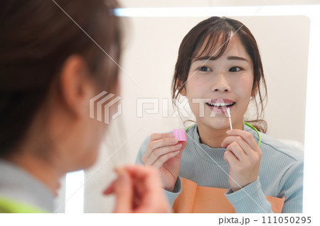 唇にワセリンを塗る女性 唇にワセリンを塗る女性 111050295