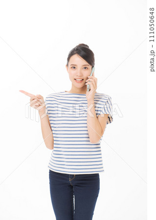 携帯電話で話をするTシャツの女性 携帯電話で話をするTシャツの女性 111050648