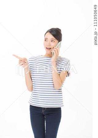 携帯電話で話をするTシャツの女性 111050649